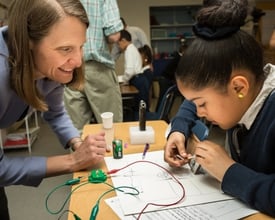 Young girl electrical engineering while adult helps