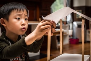 Asian kindergartner engineering a shelter