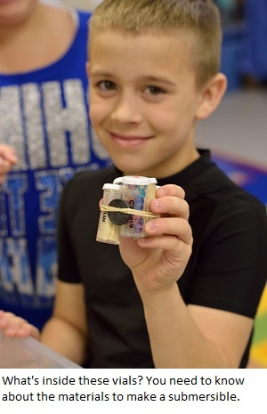 A boy holds a model submersible. Engineering is Elementary.