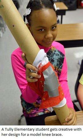 A Tully elementary student shows the creative knee brace she designed as part of a biomedical engineering challenge.