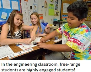 Three students work on completing a circuit and make a light bulb light up.