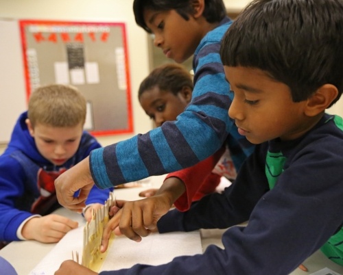 A group of diverse kids engineering a bridge